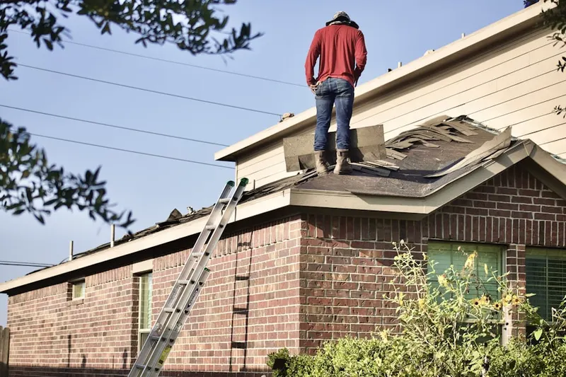 Professional roofer working on a residential roof in Weedsport